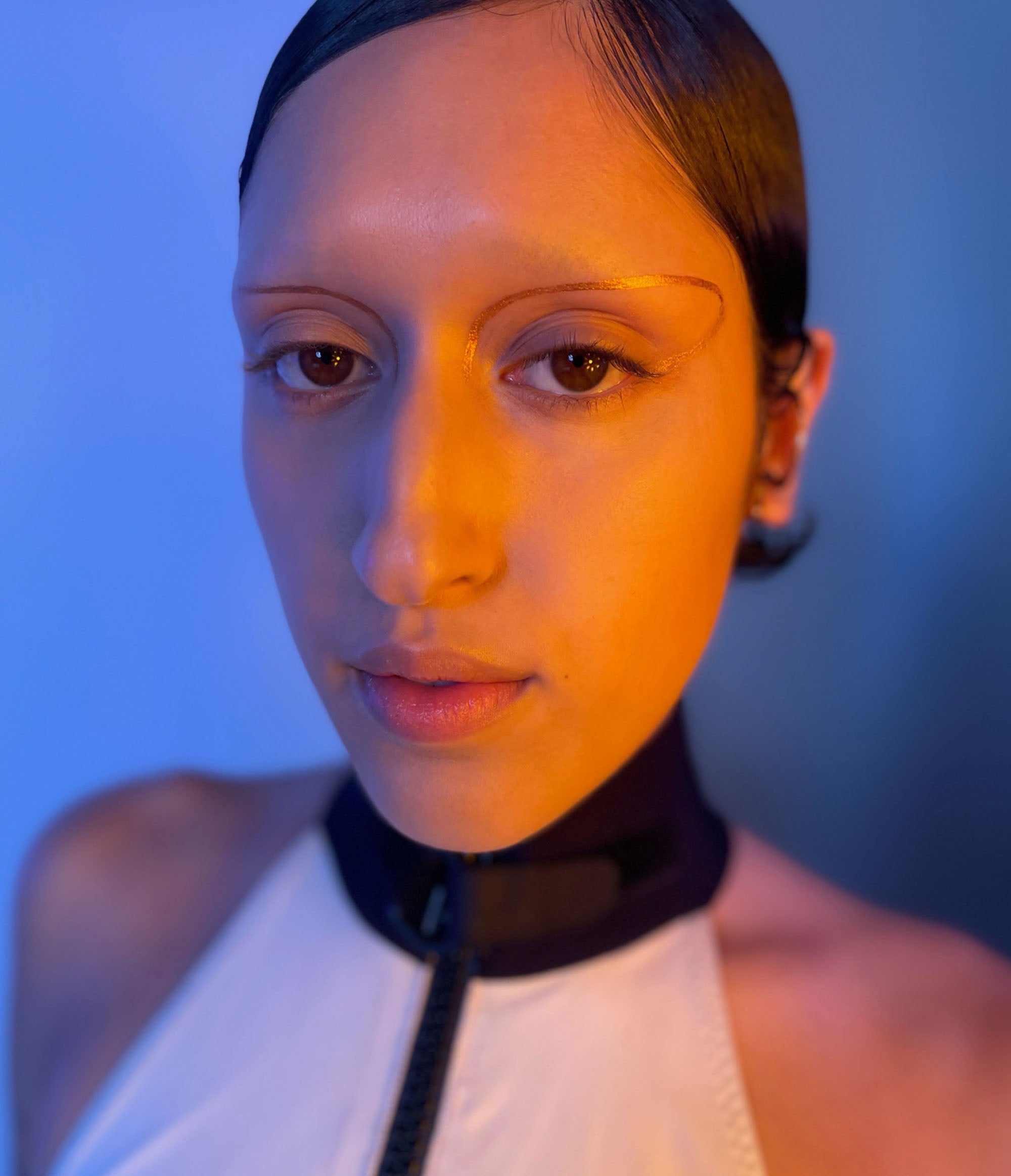 Model with medium skin tone showcasing deepdive colorpot in Eventide with a line design around their eyes.