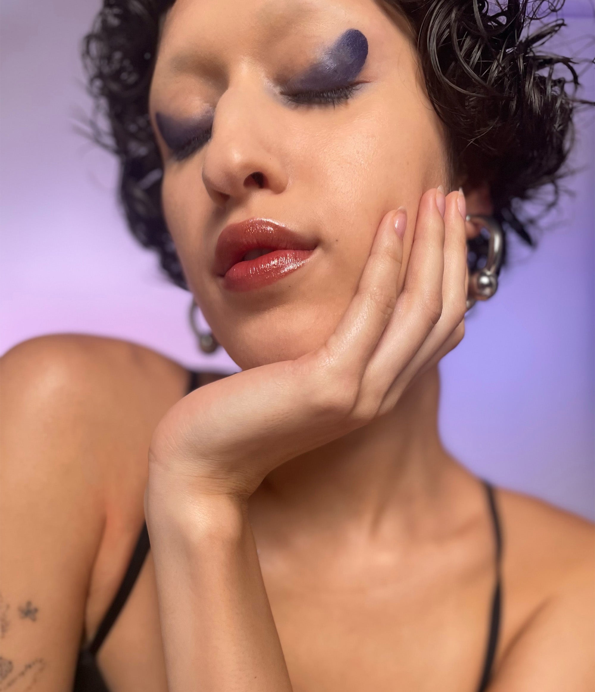 Model with medium skin tone wearing Wooly Bluecurls in a on their eyelids.