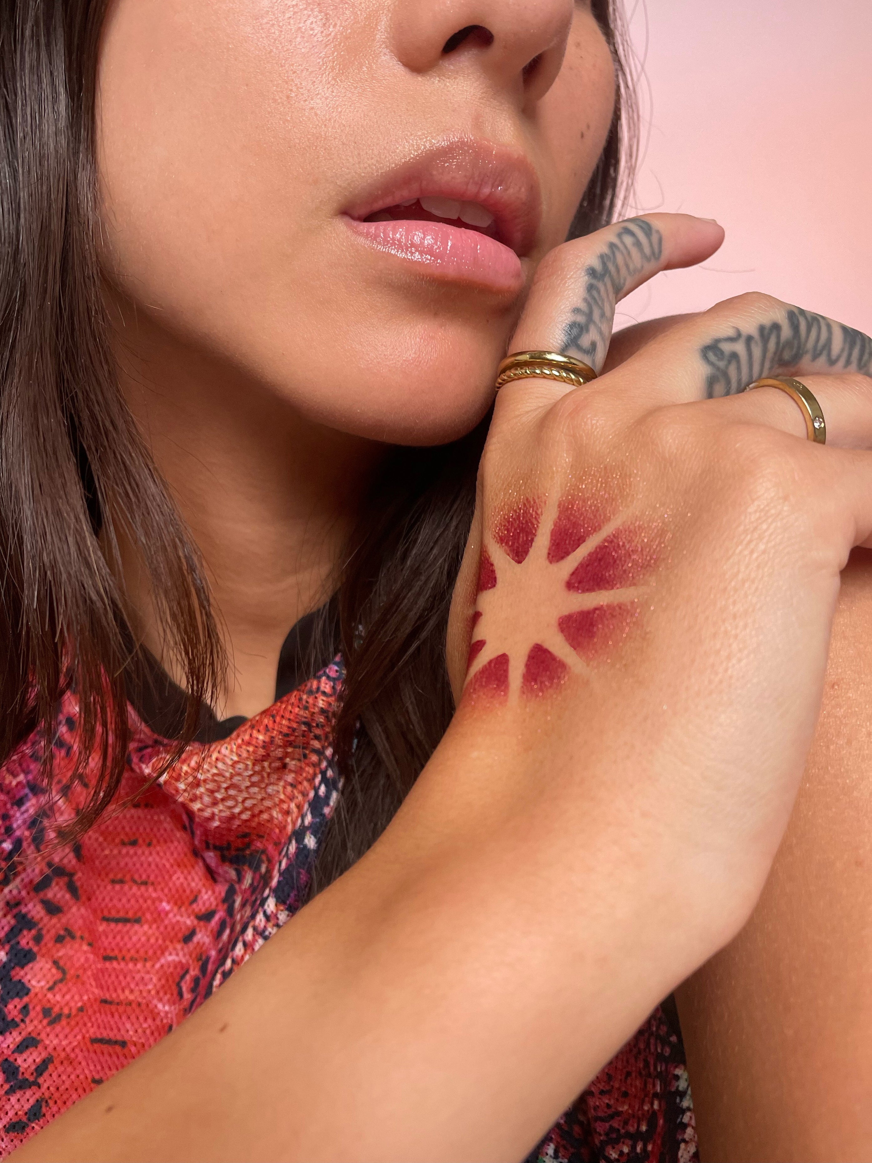 Model with medium skin tone wearing a starburst pattern on their right hand.